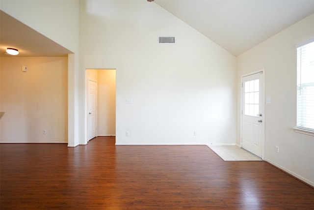 unfurnished room with a wealth of natural light, high vaulted ceiling, and dark hardwood / wood-style floors