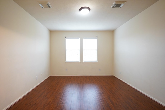 spare room featuring dark hardwood / wood-style flooring