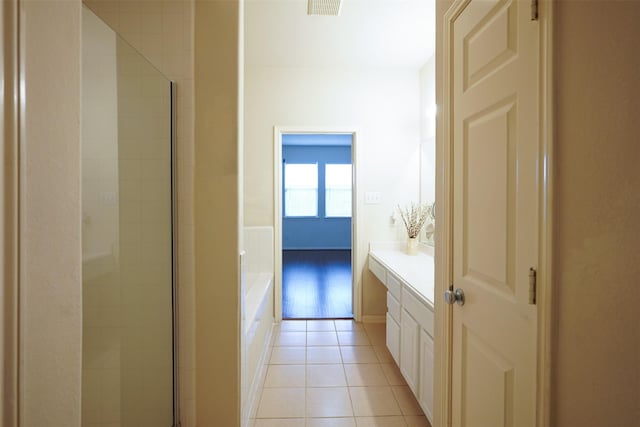 bathroom with tile patterned flooring, plus walk in shower, and vanity