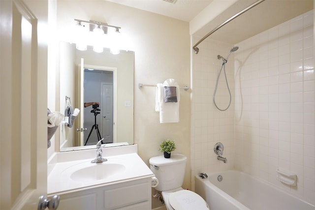 full bathroom featuring tiled shower / bath combo, vanity, and toilet