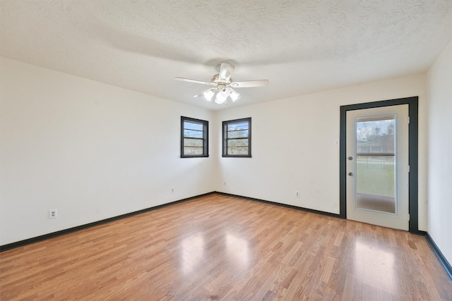 spare room with ceiling fan, light wood-type flooring, and a textured ceiling