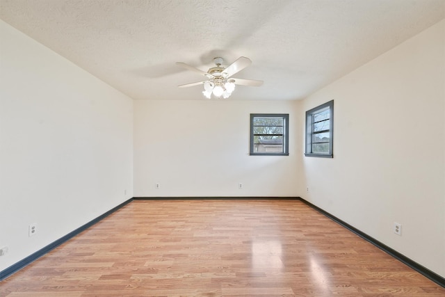 empty room with ceiling fan, light hardwood / wood-style floors, and a textured ceiling