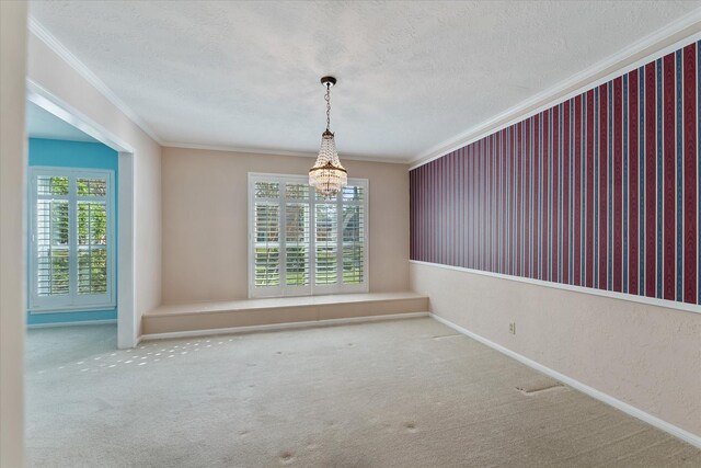 carpeted empty room with ornamental molding and a textured ceiling