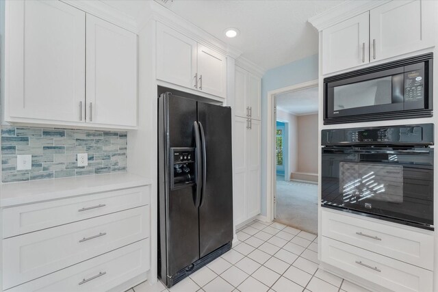 kitchen featuring backsplash, white cabinets, light tile patterned floors, and black appliances