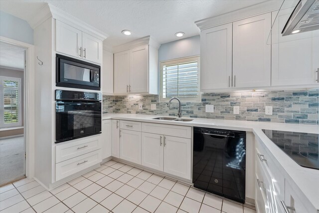 kitchen featuring decorative backsplash, sink, white cabinets, and black appliances