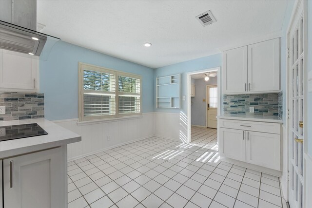 kitchen featuring a wealth of natural light, light tile patterned floors, and white cabinets