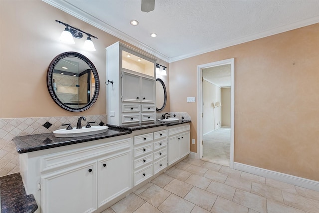 bathroom with tile patterned floors, a textured ceiling, ornamental molding, vanity, and backsplash