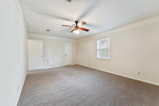 carpeted empty room with ceiling fan, crown molding, and a textured ceiling