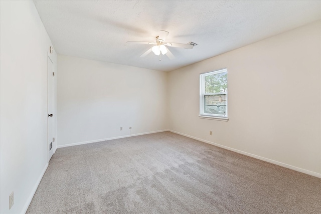 empty room featuring ceiling fan, carpet, and a textured ceiling