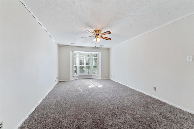 empty room with ceiling fan, ornamental molding, a textured ceiling, and carpet