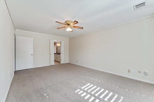 carpeted empty room featuring crown molding, a textured ceiling, and ceiling fan