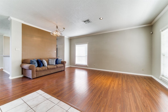 unfurnished living room with a chandelier, plenty of natural light, and crown molding