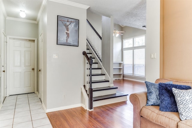 interior space featuring tile patterned flooring, ceiling fan, ornamental molding, and a textured ceiling