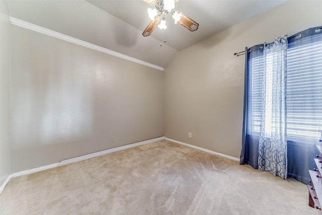 spare room with light carpet, crown molding, ceiling fan, and lofted ceiling