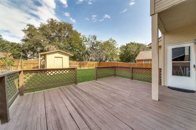 wooden deck with a storage unit and a yard