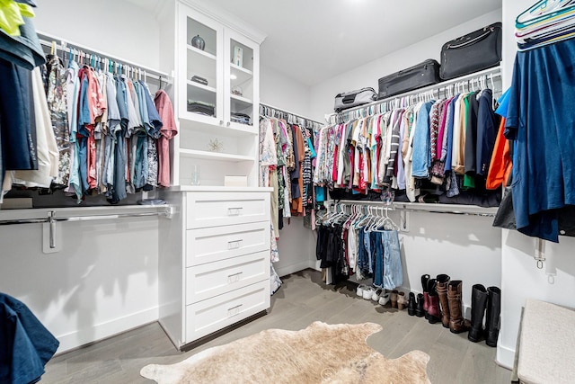 walk in closet with light wood-type flooring