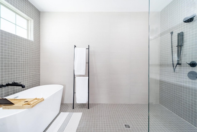 bathroom featuring tile patterned floors, independent shower and bath, and tile walls