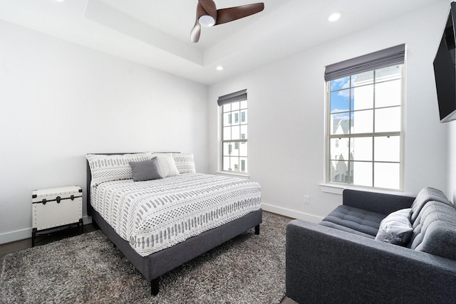 bedroom with a tray ceiling and ceiling fan