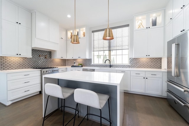 kitchen featuring white cabinets, a center island, high quality appliances, and sink