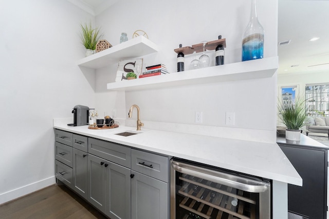 bar featuring gray cabinetry, sink, beverage cooler, dark hardwood / wood-style flooring, and pendant lighting