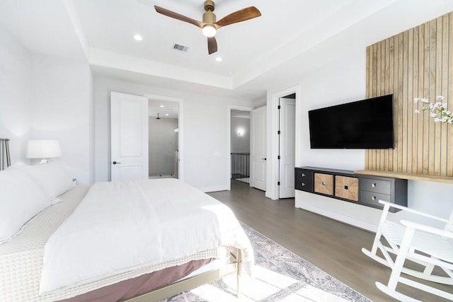 bedroom featuring a tray ceiling, ceiling fan, and dark hardwood / wood-style floors