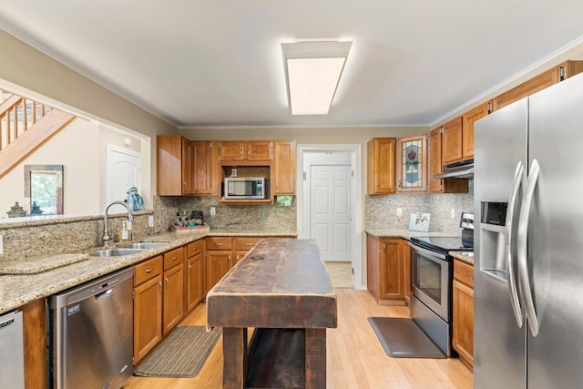 kitchen with light stone countertops, sink, appliances with stainless steel finishes, and tasteful backsplash