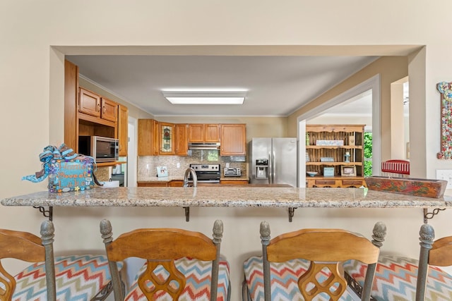 kitchen featuring decorative backsplash, appliances with stainless steel finishes, and kitchen peninsula