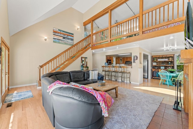 living room with wood-type flooring and a towering ceiling