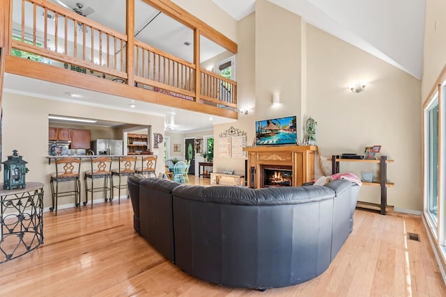 living room with light hardwood / wood-style flooring and a towering ceiling