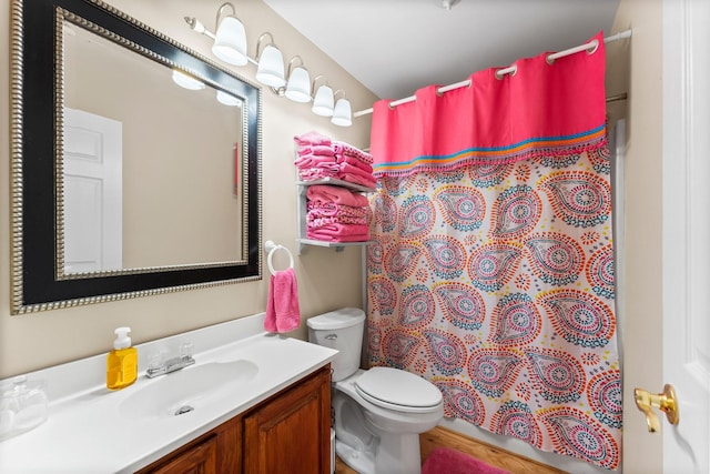 bathroom featuring a shower with shower curtain, vanity, and toilet