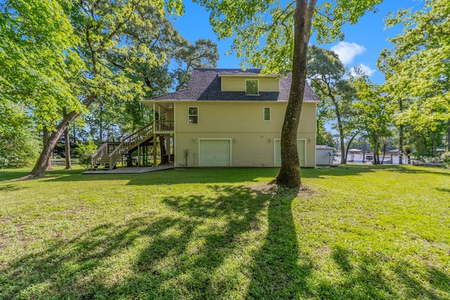 back of house with a garage, a wooden deck, and a lawn