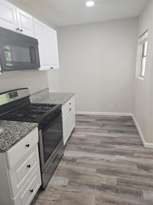 kitchen with white cabinets, light hardwood / wood-style floors, dark stone countertops, and stainless steel range with gas cooktop