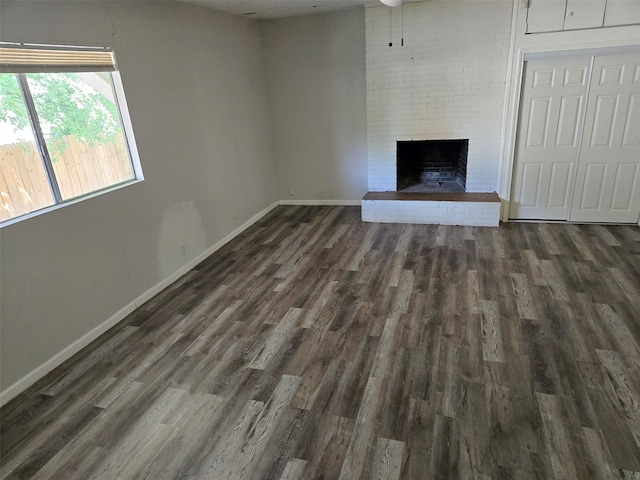 unfurnished living room featuring a fireplace and dark hardwood / wood-style floors