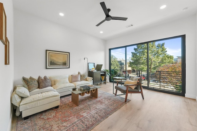 living room with ceiling fan and light wood-type flooring