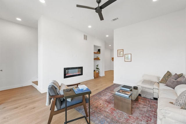 living room with ceiling fan and light wood-type flooring