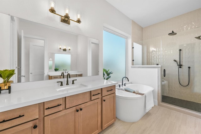 bathroom featuring shower with separate bathtub and vanity