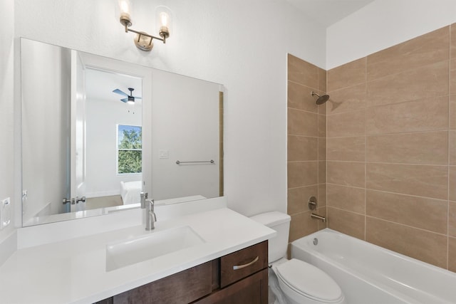 full bathroom featuring ceiling fan, toilet, vanity, and tiled shower / bath