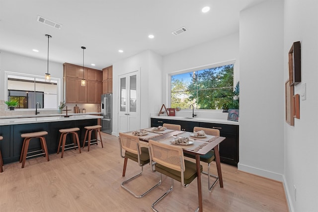 dining space featuring sink and light wood-type flooring