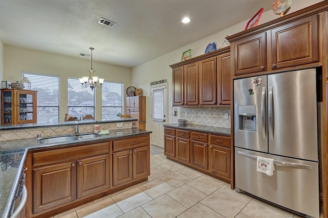 kitchen with pendant lighting, an inviting chandelier, sink, light tile patterned floors, and stainless steel fridge with ice dispenser