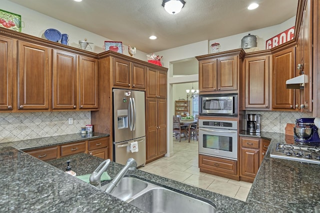 kitchen featuring tasteful backsplash, sink, light tile patterned flooring, and stainless steel appliances