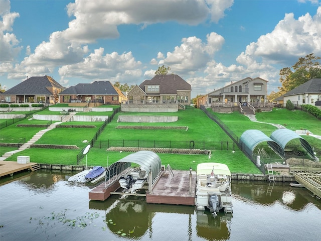 view of dock with a lawn and a water view