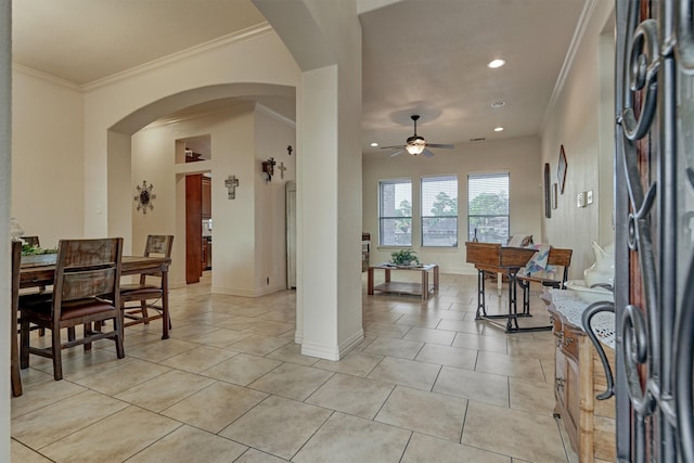 dining area with ceiling fan, crown molding, and light tile patterned flooring