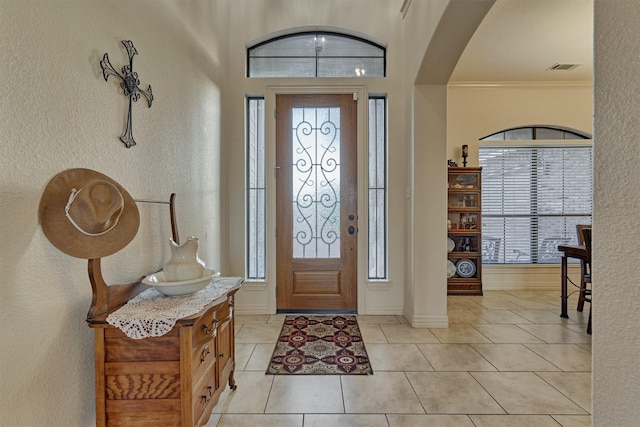 entrance foyer featuring light tile patterned floors and ornamental molding