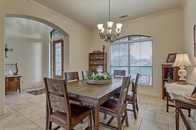 tiled dining area featuring crown molding and a chandelier