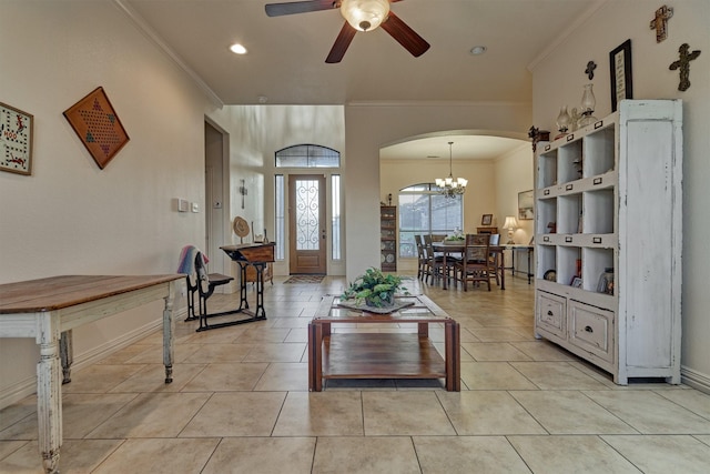 living room with light tile patterned floors, ceiling fan with notable chandelier, and ornamental molding