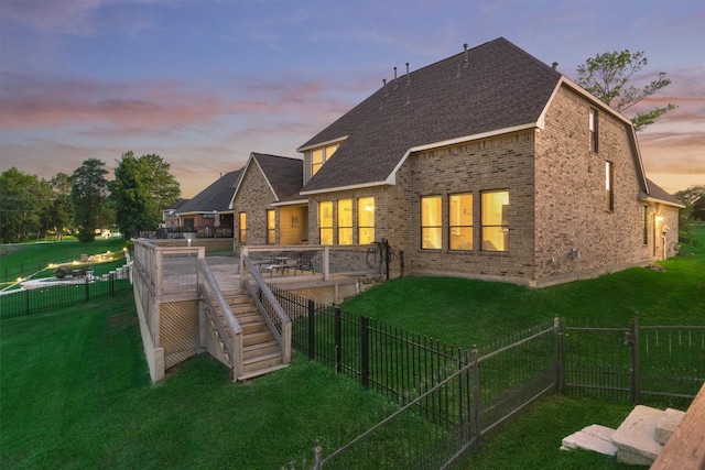 back house at dusk featuring a yard