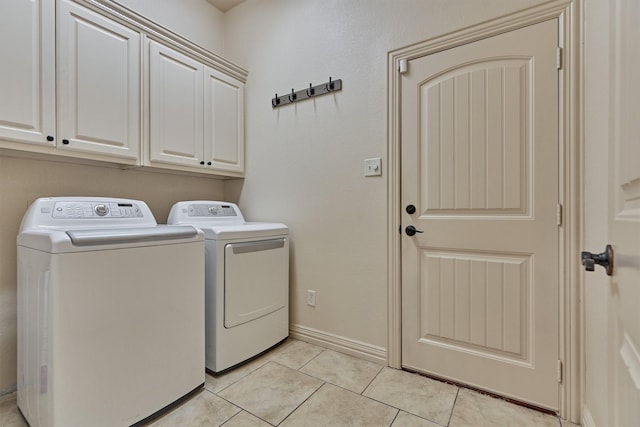 washroom with cabinets, separate washer and dryer, and light tile patterned flooring