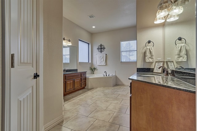 bathroom with a bathing tub, tile patterned flooring, and vanity