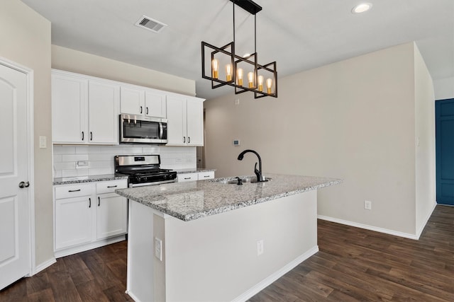 kitchen featuring white cabinetry, stainless steel appliances, and hanging light fixtures