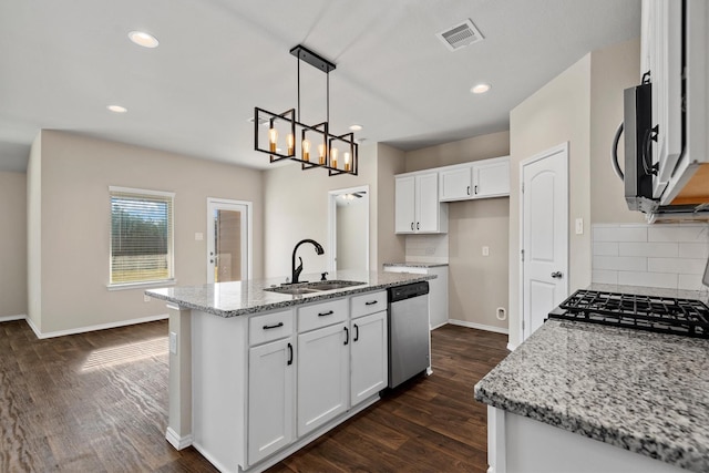 kitchen featuring white cabinets, sink, light stone countertops, an island with sink, and stainless steel appliances